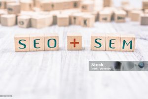 The Words SEO And SEM Formed By Wooden Blocks On White Table