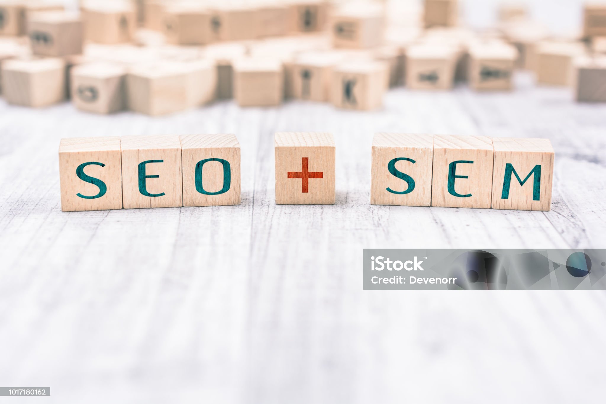 The Words SEO And SEM Formed By Wooden Blocks On White Table