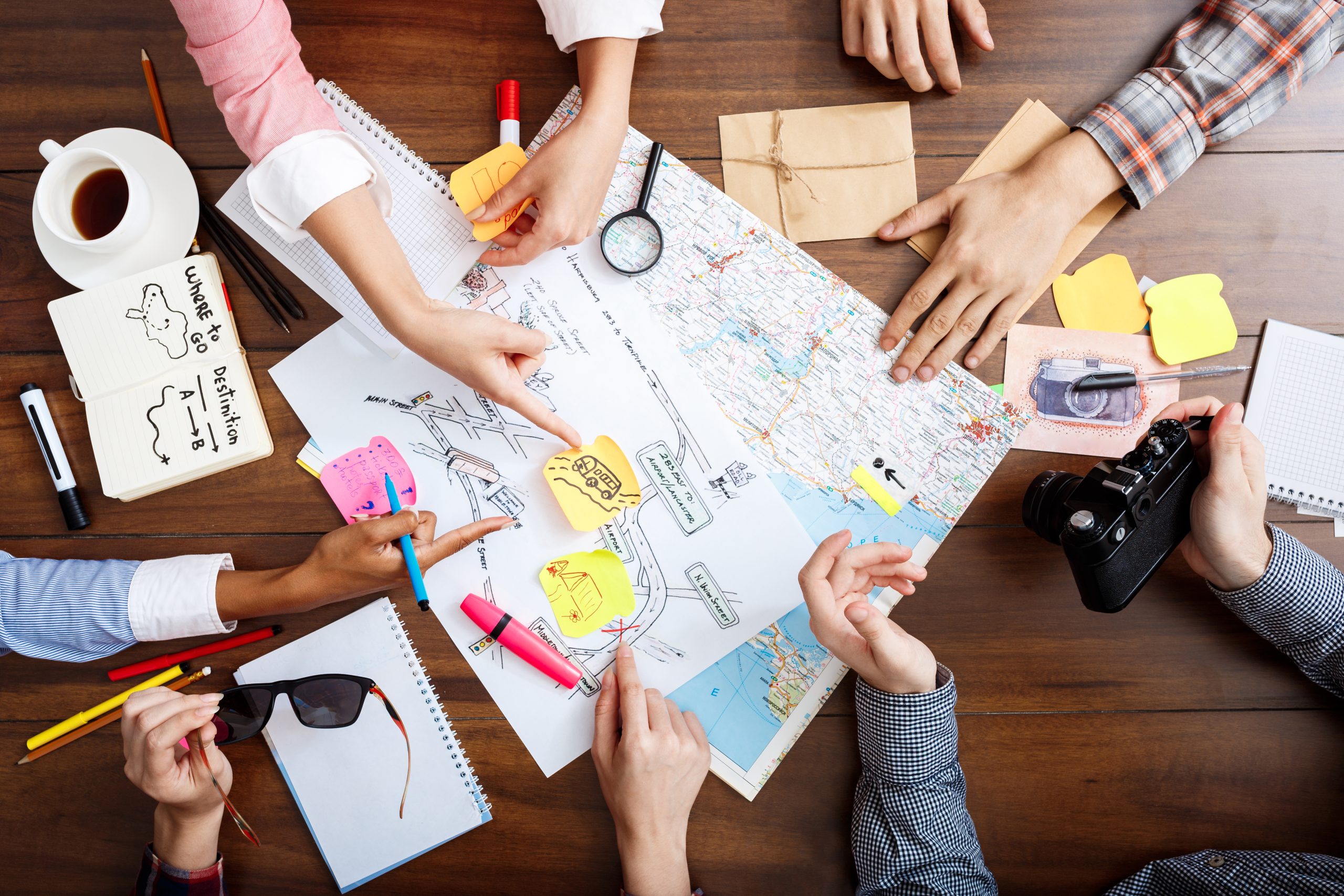 Picture of businessmen's hands on wooden table with documents and drafts